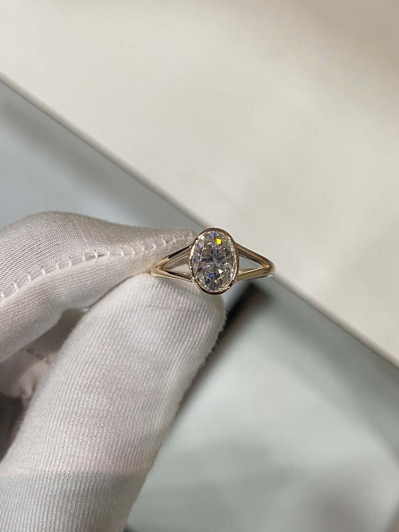 Op de afbeelding: Een gouden ring met een grote ovale diamant, gezet in een delicaat, gesplitst ontwerp.