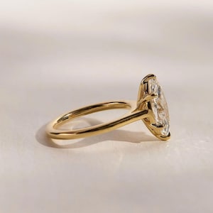 May include: A gold engagement ring with a large oval-shaped diamond set in a prong setting.