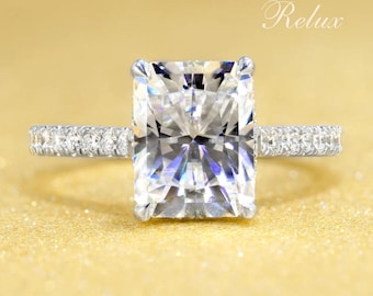 May include: A silver ring with a large, rectangular, clear diamond and a band of smaller diamonds.
