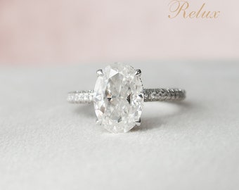 May include: A silver engagement ring with a large oval-shaped diamond and a band of smaller diamonds.