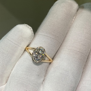 Op de afbeelding: Een gouden ring met een grote ovale diamant gezet in een gesplitste schouder.