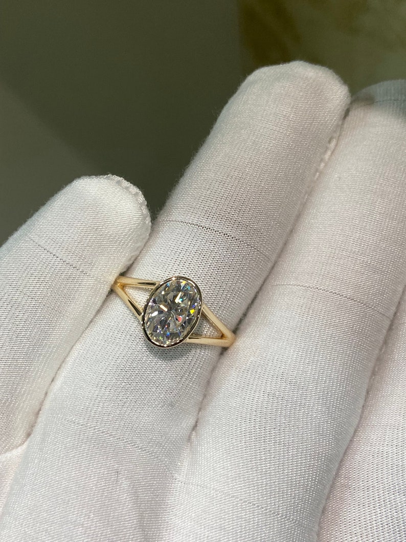Op de afbeelding: Een gouden ring met een grote ovale diamant gezet in een gesplitste schouder.