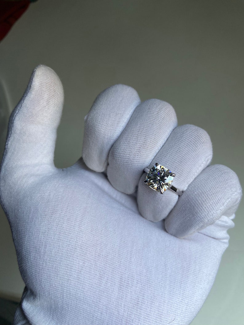 May include: A white gold ring with a large, clear, square-shaped diamond.
