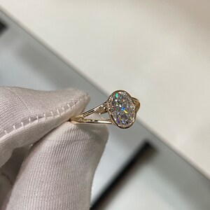 Op de afbeelding: Een gouden verlovingsring met een ovale diamant.