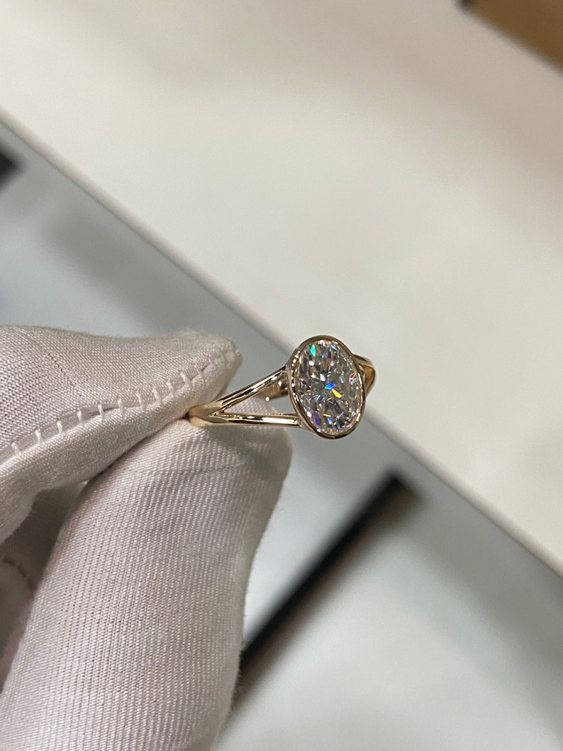 Op de afbeelding: Een gouden verlovingsring met een ovale diamant.