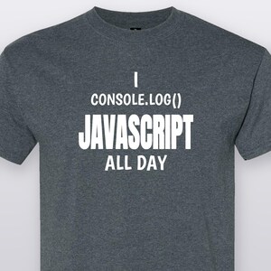 May include: A dark heather grey short-sleeved t-shirt featuring white text that reads I CONSOLE.LOG() JAVASCRIPT ALL DAY. The shirt has a crew neckline and a standard fit, made from a textured fabric with a visible blend of light and dark grey fibers.
