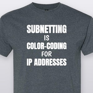 May include: A dark heather gray short-sleeve t-shirt featuring the white text SUBNETTING IS COLOR-CODING FOR IP ADDRESSES printed in a bold, sans-serif font across the chest. The garment has a crew neckline and a standard fit.
