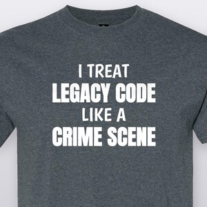 May include: A dark heather gray crew neck t-shirt featuring the white text I TREAT LEGACY CODE LIKE A CRIME SCENE printed in a bold, sans-serif font across the chest. The garment has short sleeves and a standard fit with a ribbed neckline.