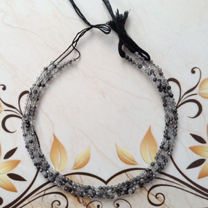 May include: A strand of black and clear faceted beads with a black cord and tassel.