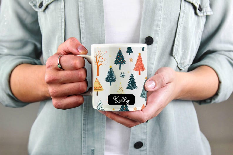 Puede incluir: Taza de cer&aacute;mica blanca con un patr&oacute;n de &aacute;rbol de Navidad y el nombre "Kelly" en la parte delantera.
