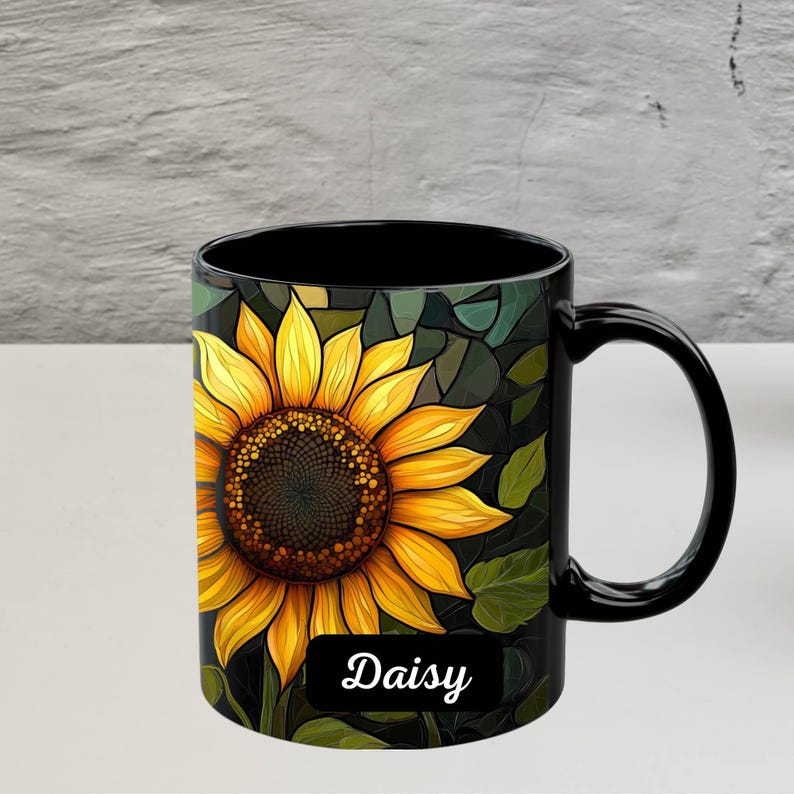 May include: Black coffee mug with a sunflower design and the word "Daisy" printed on the bottom.