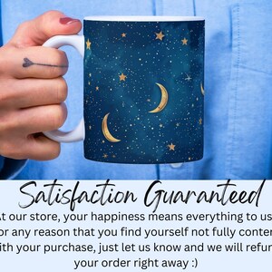 Puede incluir: Una taza de cer&aacute;mica blanca con un dise&ntilde;o azul y dorado con una luna creciente y estrellas. La taza tiene un asa y est&aacute; siendo sostenida por una mano. El texto "Satisfaction Guaranteed" se muestra debajo de la taza.