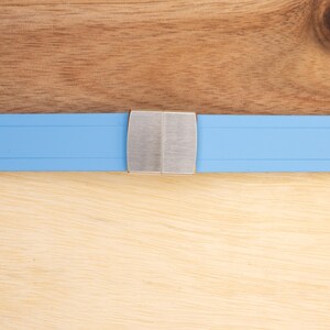 May include: A light blue watch band with a silver buckle.