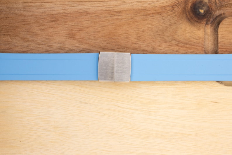 May include: A light blue watch band with a silver buckle.