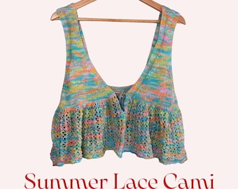 May include: A colorful, hand-knitted Summer Lace Cami hangs on a wooden hanger. The cami features a scoop neck and a ruffled hem. The text "Summer Lace Cami" is displayed below the cami, with the designer's name, "lucky777loops," underneath.