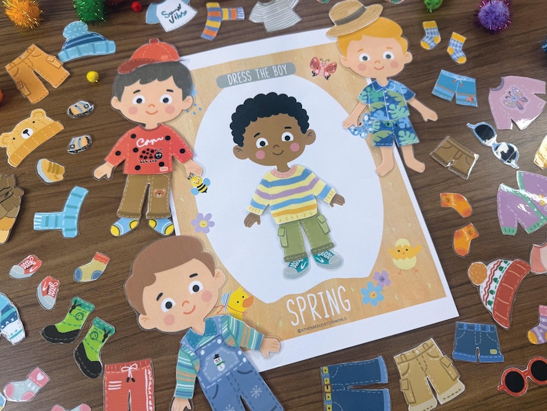 Pode incluir: Um conjunto de bonecos de papel intitulado Dress The Boy Spring com uma personagem central vestindo um su&eacute;ter listrado e cal&ccedil;as cargo verdes, rodeado por v&aacute;rios itens de vestu&aacute;rio intercambi&aacute;veis como chap&eacute;us, camisas, cal&ccedil;as e sapatos.