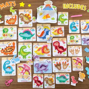 K&ouml;nnte beinhalten: Eine Sammlung von Dinosaurier-Knetmatten mit verschiedenen bunten Knetdinosauriern wie einem Tyrannosaurus Rex, Stegosaurus und Triceratops, begleitet von kleinen Kunststoffwerkzeugen wie einer Rolle, einer Schaufel und einer Schere.