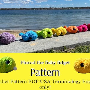 Op de afbeelding: Een haakpatroon voor een kleurrijk visvormig fidget-speelgoed genaamd "Finrod the fishy fidget". Het patroon is beschikbaar als PDF-download en gebruikt Amerikaanse terminologie in het Engels.