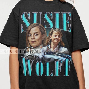 May include: Black t-shirt with a vintage-style graphic of Susie Wolff, a race car driver, with the text "Susie Wolff" in a blue and white font.