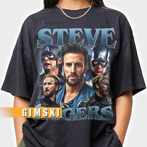 Puede incluir: Camiseta unisex gris oscuro con un gr&aacute;fico del personaje Steve Rogers de las pel&iacute;culas de los Vengadores. El dise&ntilde;o incluye la palabra "STEVE" en azul y el texto "GIMSKIGERS". La camiseta es de estilo unisex.