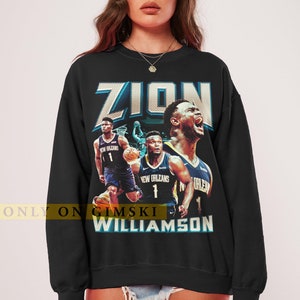 May include: Black sweatshirt featuring a graphic of Zion Williamson in a New Orleans Pelicans jersey. The design includes the name "ZION" in large, stylized letters and the name "WILLIAMSON" below. The text "ONLY ON GIMSKI" is also visible.