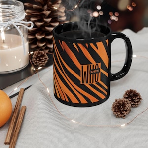 May include: Black coffee mug with a tiger stripe pattern and the text "WHO DEY" in a white box.