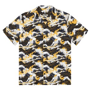 May include: A short-sleeved button-down shirt with a white background and a repeating pattern of black and gold waves. The shirt has a collar and a button closure.