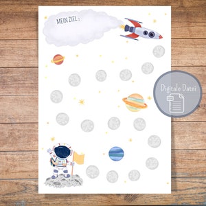 Puede incluir: Una hoja de actividades imprimible con temática espacial con un cohete, planetas, estrellas y un astronauta. La hoja tiene el texto "Mein Ziel" escrito en ella.