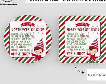 Könnte beinhalten: Ein druckbarer Weihnachtsanhänger mit rot-grünem gestreiftem Hintergrund. Der Anhänger zeigt eine Elfenillustration und den Text "OFFICIAL NORTH POLE HOT COCOA I BROUGHT YOU A SWEET WE LOVE IN THE NORTH POLE. WITH HELP FROM AN ADULT POUR HOT MILK ON TOP OF THE MAGIC CHOCOLATE BALL AND WATCH IT EXPLODE FROM WITHIN. STIR & ENJOY". Der Anhänger ist 6,35 cm x 6,35 cm groß.