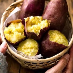 May include: A wicker basket filled with sweet potatoes. Some of the potatoes are cut open, revealing their soft, yellow flesh.
