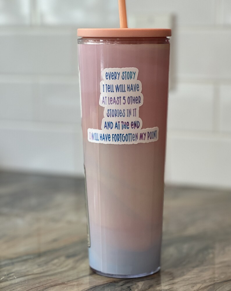 Puede incluir: Un vaso de color rosa y azul degradado con una pegatina blanca que dice "Every story I tell will have at least 5 other stories in it and at the end I will have forgotten my point."