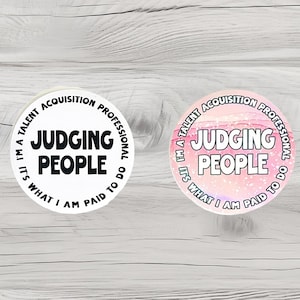 May include: Two round stickers with the text "I'm a talent acquisition professional. It's what I am paid to do. Judging people." One sticker is white with black text, the other is pink with white text.