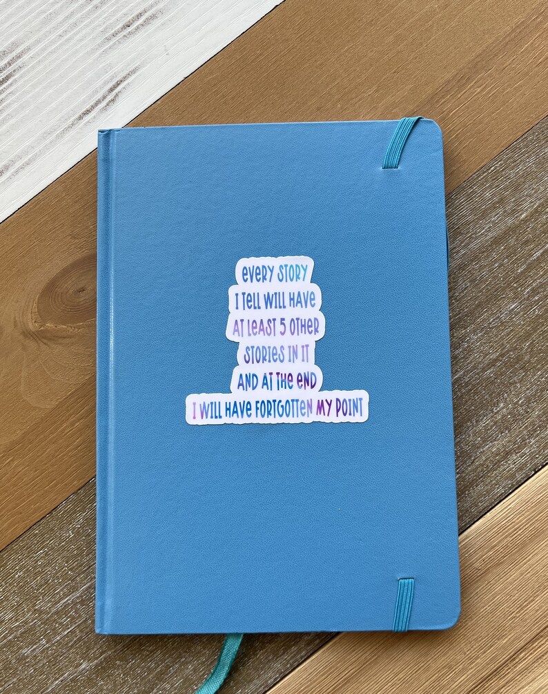 Puede incluir: Un cuaderno azul con una pegatina que dice "Cada historia que cuento tendr&aacute; al menos 5 historias m&aacute;s en ella y al final me habr&eacute; olvidado de mi punto."