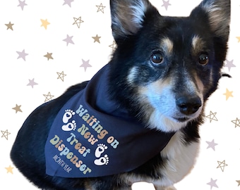 May include: A black and tan dog wearing a navy blue bandana. The bandana has the text "Waiting on New Treat Dispenser" with paw prints. The background is white with gold, gray, and lavender stars.