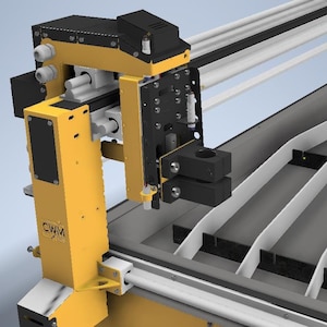 May include: Close-up of a yellow industrial cutting machine with a black and yellow arm and a white cutting bed. The cutting bed has a series of black and white slats.