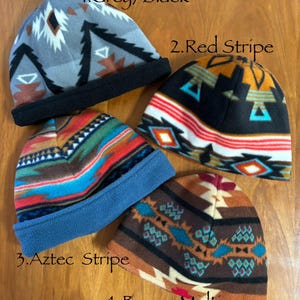 May include: Four fleece hats with different patterns. The hats are labeled 1. Grey/Black, 2. Red Stripe, 3. Aztec Stripe, and 4. Brown Multi.