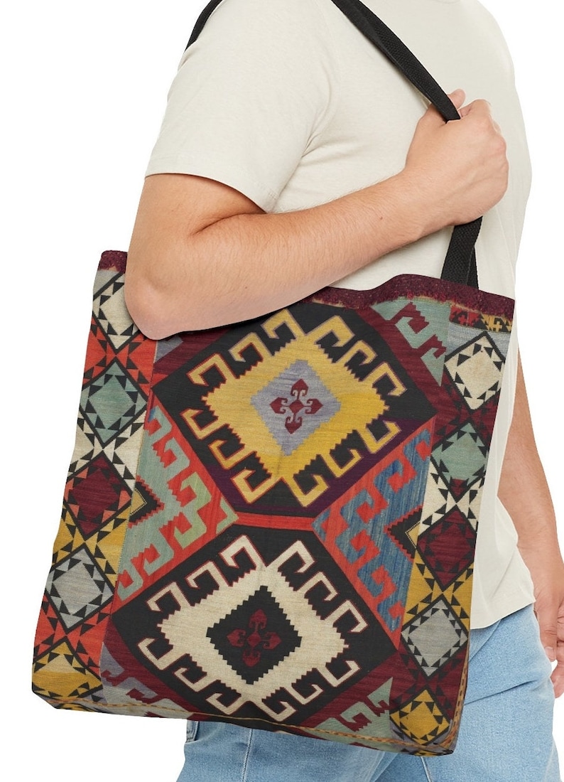 May include: A black tote bag with a colorful geometric pattern. The pattern features squares, diamonds, and triangles in shades of red, blue, yellow, and green.