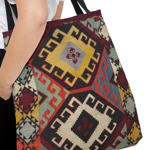 May include: A large tote bag with a colorful geometric pattern. The pattern is reminiscent of a traditional rug or tapestry. The bag has black straps.