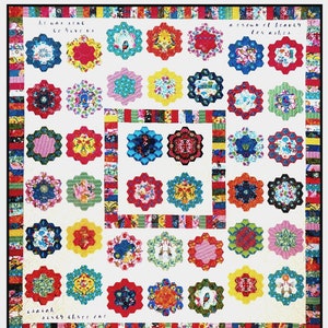 May include: A colorful quilt with a white background and numerous hexagon-shaped floral designs in various colors. The quilt features text that reads "he was sent to give us" and "a crown of beauty for ashes" and "isaiah six three one."