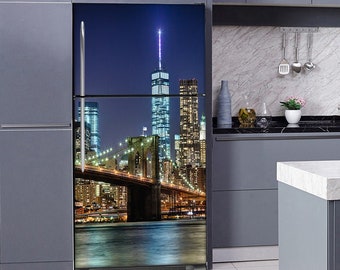 Pode incluir: Um refrigerador com um painel de porta personalizado que apresenta uma vista noturna da cidade de Nova York com a Ponte do Brooklyn e a Torre da Liberdade ao fundo.