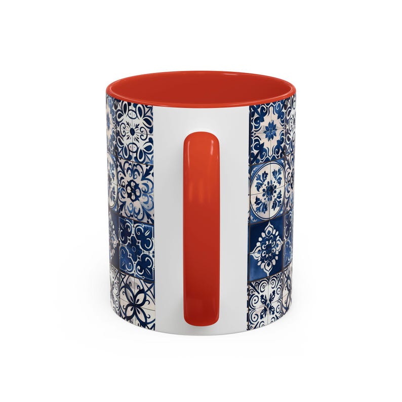 May include: A white ceramic mug with a blue and white patterned design. The mug has an orange handle and a red rim.