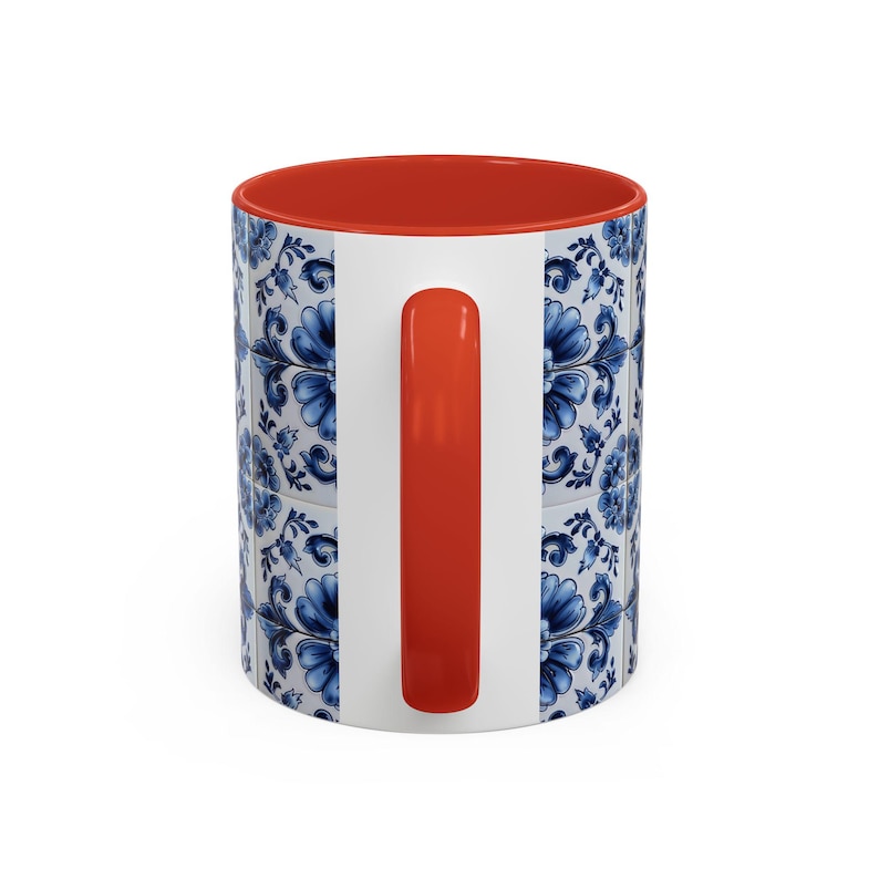 May include: White ceramic mug with a blue floral tile pattern. The interior and handle are bright orange. The mug features a classic design, perfect for coffee, tea, or any favourite beverage.