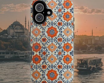 Op de afbeelding: Een smartphonehoesje met een herhalend bloemenpatroon van oranje, lichtoranje en donkerblauwe bloemblaadjes op een crèmekleurige achtergrond. Het hoesje heeft een zwarte camera-uitsparing linksboven met twee ronde cameralenzen en een flitser.
