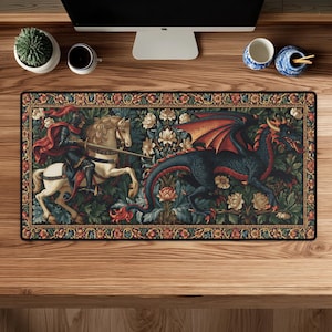 May include: A rectangular desk mat featuring a detailed tapestry-style illustration of a knight in dark armour riding a white horse and wielding a sword against a large, dark blue dragon with red wings, surrounded by intricate floral patterns.