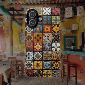 Op de afbeelding: Een rechthoekig smartphonehoesje met een rasterpatroon van kleurrijke vierkante tegels. Elke tegel toont een uniek bloemmotief of geometrisch patroon in tinten geel, rood, blauw, groen en wit. Het hoesje heeft een zwarte camera-uitsparing.