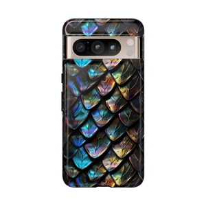 May include: A smartphone case featuring a repeating iridescent dragon scale pattern in shades of deep blue, purple, and gold. The case has a horizontal camera bar cutout at the top, revealing the phone's triple camera lenses and flash sensor.