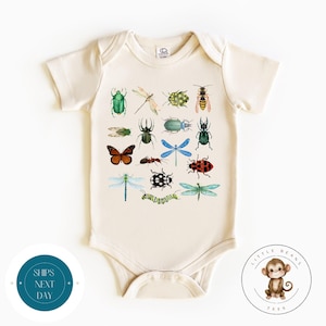 May include: A cream-coloured baby onesie with a colourful print of various insects, including butterflies, ladybugs, beetles, and dragonflies.