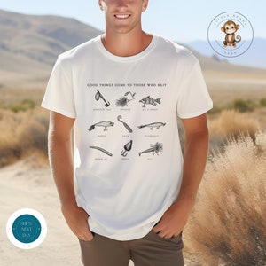 May include: White t-shirt with the text "Good things come to those who bait" and illustrations of different fishing lures, including a booster tail, spinner, jig and spoon, popper, grub, crankbait, worm jig, spoon, and fly.