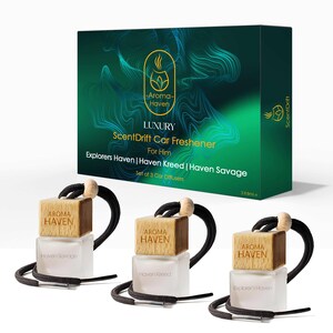 May include: A set of three car air fresheners with wooden tops and frosted glass bottles. The box and fresheners feature the "Aroma Haven" logo and the text "ScentDrift Car Freshener For Him". The box is dark green with a swirling pattern.
