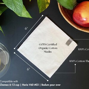 May include: A square, off-white organic cotton muslin coffee filter measuring 6 inches by 6 inches. It features a small 100% cotton tab and 100% cotton thread stitching. The text on the filter reads GOTS Certified Organic Cotton Muslin.